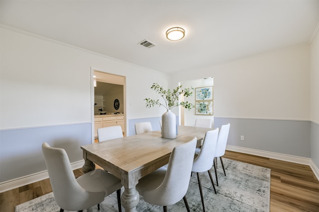 dining area with ornamental molding and wood-type flooring