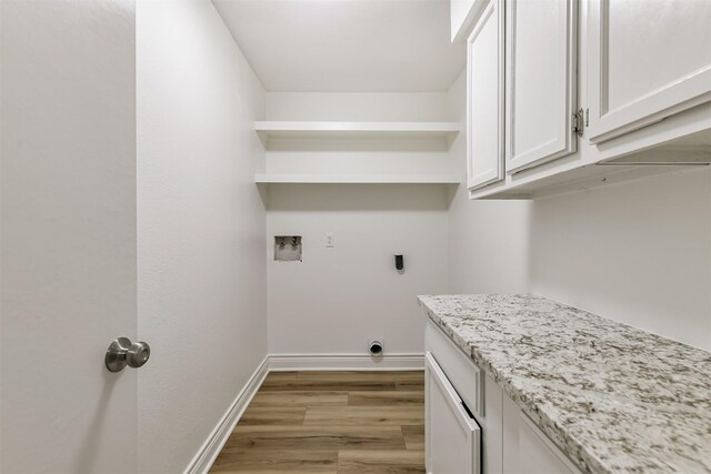 clothes washing area with washer hookup, light hardwood / wood-style flooring, cabinets, and electric dryer hookup