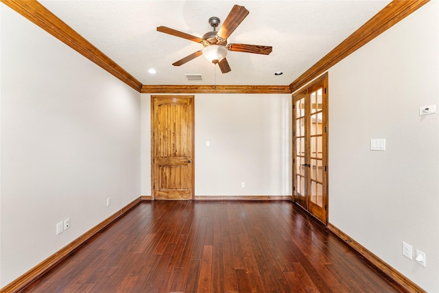 spare room with crown molding, visible vents, dark wood-type flooring, a ceiling fan, and baseboards