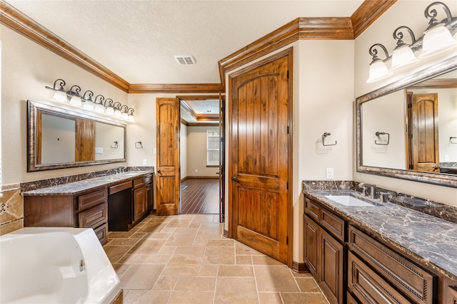 full bathroom with crown molding, visible vents, and a sink