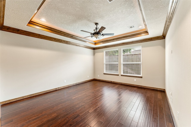 unfurnished room featuring dark wood-style floors, a raised ceiling, crown molding, and a textured ceiling