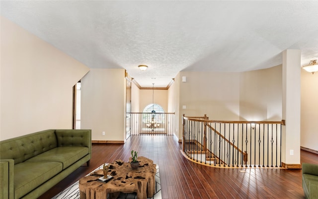 living area featuring baseboards, a textured ceiling, and hardwood / wood-style floors