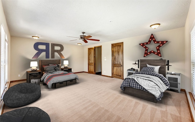 bedroom featuring carpet floors, a ceiling fan, baseboards, and a textured ceiling