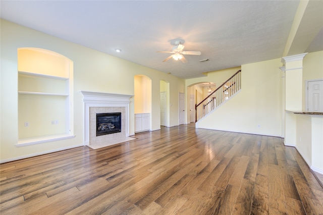 unfurnished living room featuring hardwood / wood-style flooring, ceiling fan, and a tile fireplace