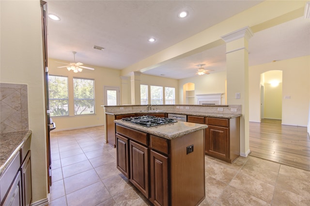 kitchen featuring light hardwood / wood-style floors, ceiling fan, a center island, and decorative columns