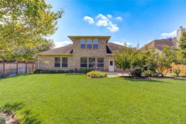 rear view of property featuring a yard