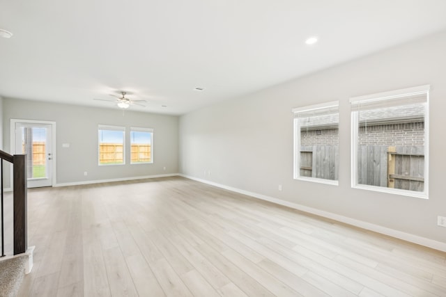 empty room with ceiling fan and light hardwood / wood-style floors