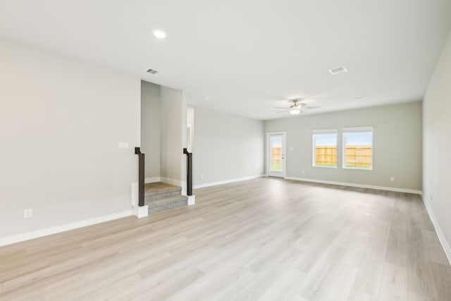 empty room with ceiling fan and light hardwood / wood-style floors