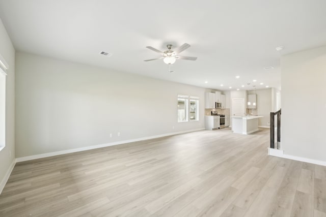 unfurnished living room with ceiling fan and light wood-type flooring