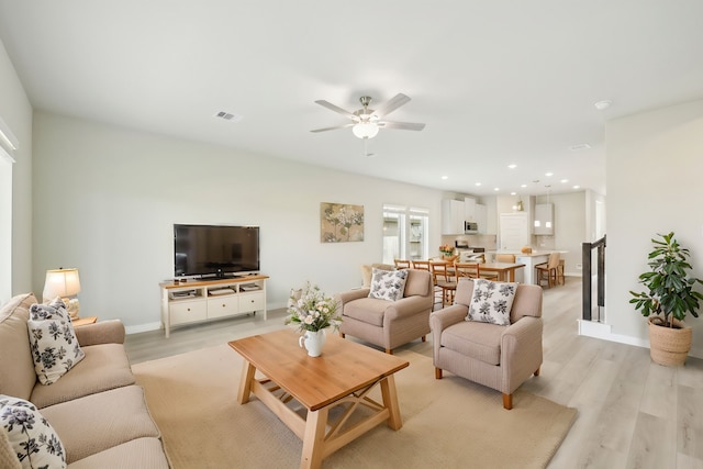 living room with light wood-type flooring and ceiling fan