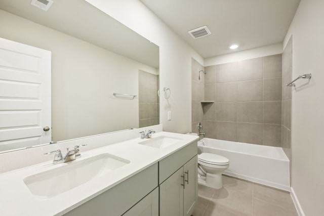 full bathroom featuring toilet, vanity, tiled shower / bath, and tile patterned floors