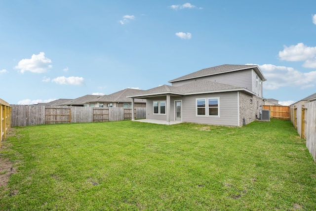 rear view of house featuring a patio, central AC, and a yard