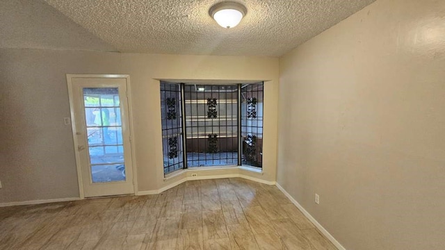 spare room featuring wood-type flooring and a textured ceiling