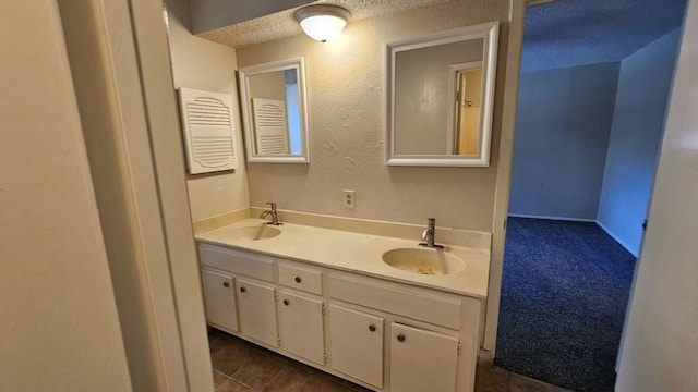 bathroom featuring tile patterned flooring, a textured ceiling, and vanity