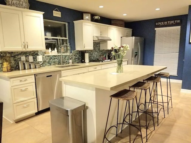 kitchen featuring a center island, white cabinets, stainless steel appliances, and sink