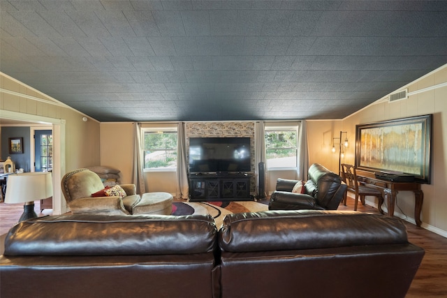 living room with crown molding, wood-type flooring, and lofted ceiling