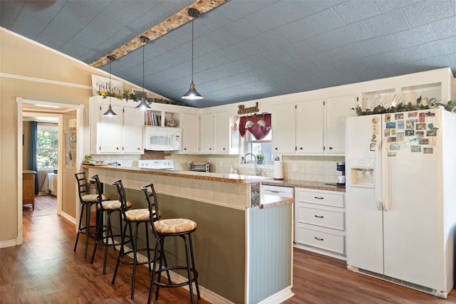 kitchen featuring white appliances, dark hardwood / wood-style floors, vaulted ceiling, white cabinetry, and hanging light fixtures