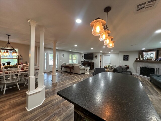 kitchen featuring pendant lighting, dark hardwood / wood-style flooring, and decorative columns