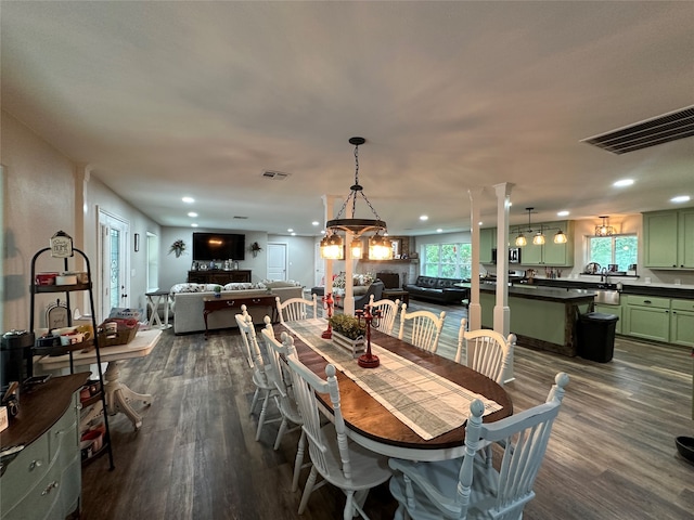 dining room with a chandelier, dark wood-type flooring, and a healthy amount of sunlight