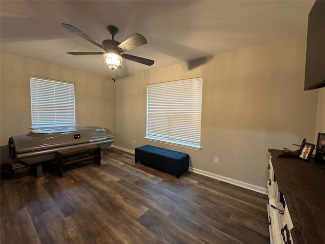 misc room with ceiling fan and dark wood-type flooring