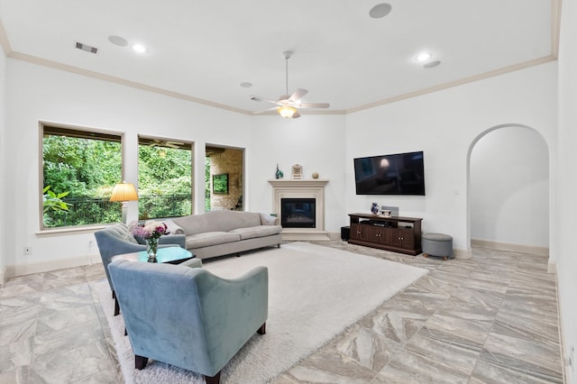 tiled living room featuring ceiling fan and crown molding