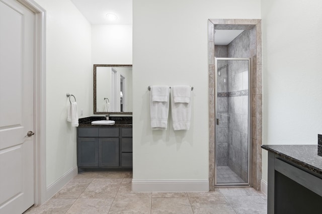 bathroom featuring a shower with door, tile patterned flooring, and vanity