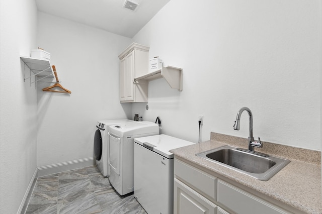 clothes washing area featuring sink, cabinets, separate washer and dryer, and light tile patterned floors