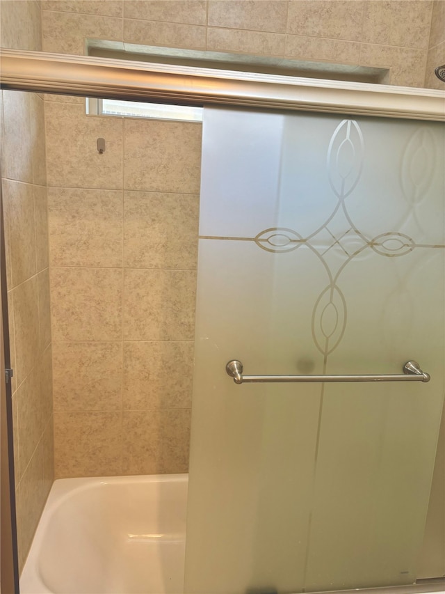 bathroom with shower / bath combination with glass door