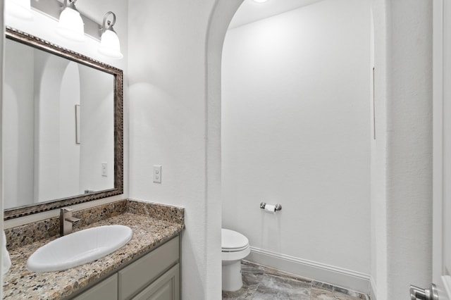 bathroom with toilet, vanity, and tile patterned floors