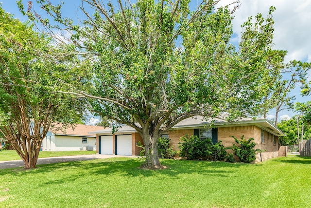 ranch-style home featuring a garage and a front lawn