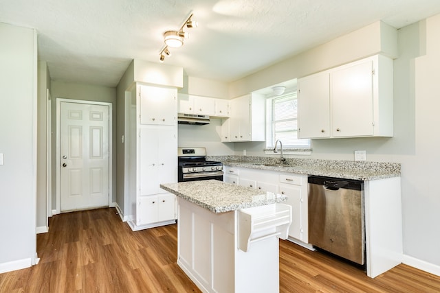 kitchen featuring stainless steel appliances, white cabinetry, sink, light wood-type flooring, and track lighting