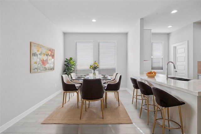 dining space featuring light hardwood / wood-style flooring, a healthy amount of sunlight, and sink