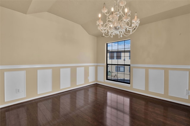 spare room featuring vaulted ceiling, wood-type flooring, and a notable chandelier