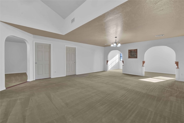 interior space featuring a textured ceiling, carpet floors, lofted ceiling, and a chandelier