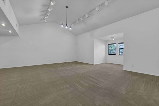 carpeted empty room with track lighting and a chandelier