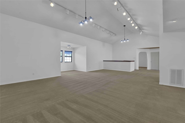 unfurnished living room with carpet, rail lighting, and lofted ceiling