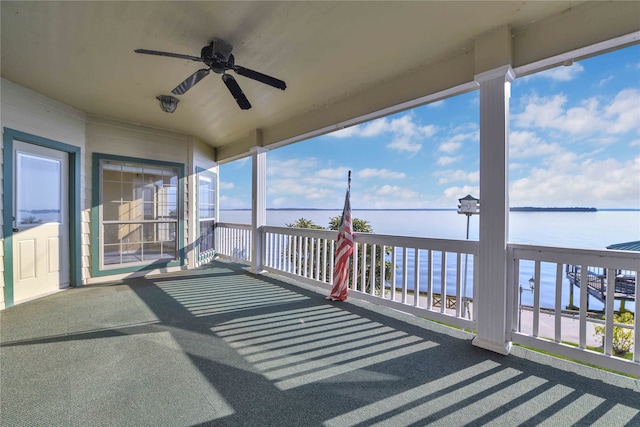 wooden terrace with ceiling fan and a water view