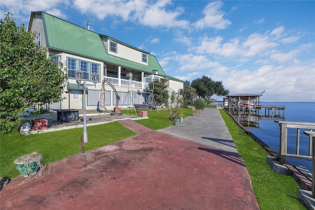 exterior space with a yard, a boat dock, and a water view