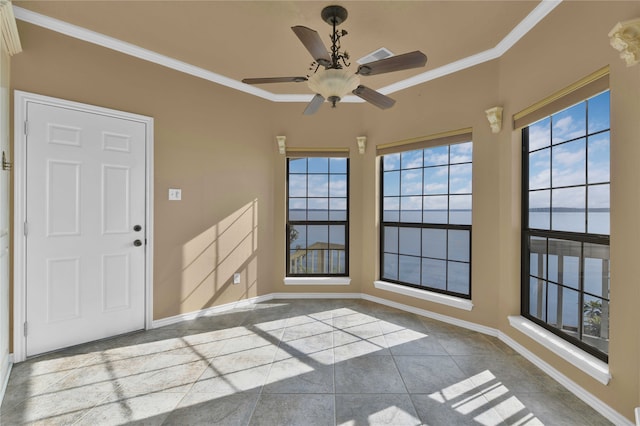 unfurnished room featuring ceiling fan, ornamental molding, and light tile patterned floors