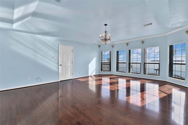 unfurnished room featuring hardwood / wood-style flooring, a textured ceiling, an inviting chandelier, and crown molding