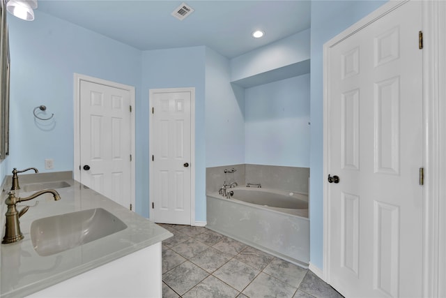 bathroom with tile patterned flooring, vanity, and a tub to relax in