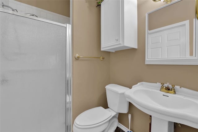 bathroom featuring sink, an enclosed shower, and toilet