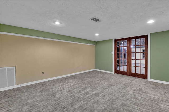 carpeted spare room with french doors and a textured ceiling