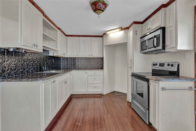 kitchen featuring hardwood / wood-style floors, appliances with stainless steel finishes, sink, and white cabinets