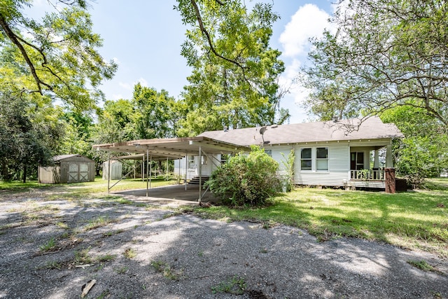 rear view of house featuring a storage shed, a lawn, and a carport