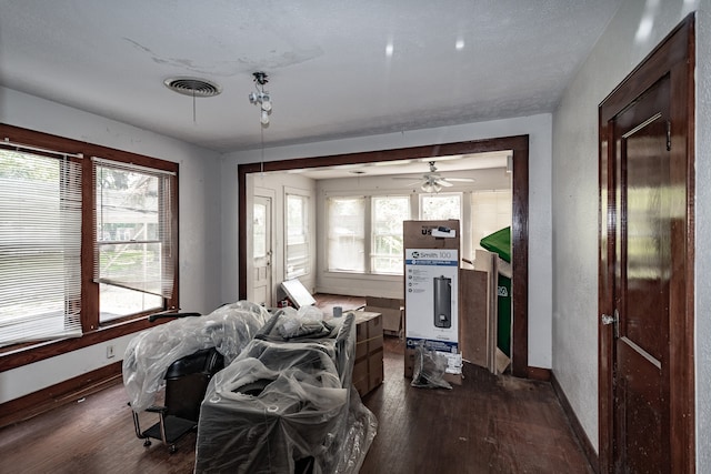 living room featuring dark wood-type flooring and a healthy amount of sunlight