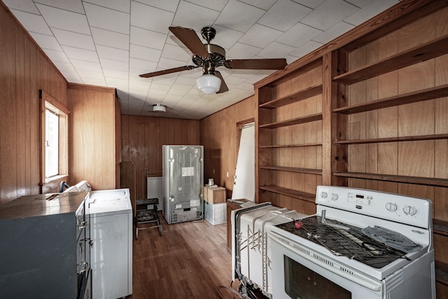 kitchen featuring wood walls, washer / clothes dryer, hardwood / wood-style flooring, white range, and ceiling fan