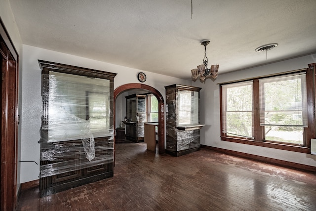 unfurnished dining area featuring dark hardwood / wood-style flooring and a chandelier