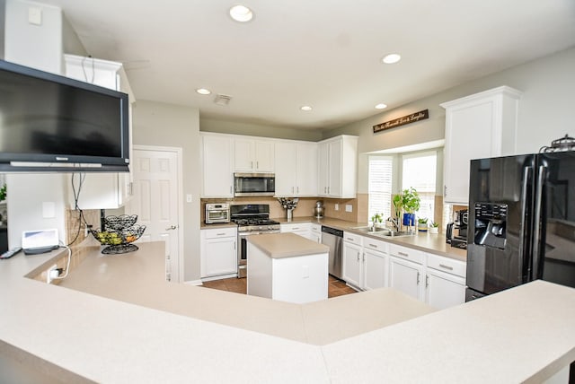 kitchen with stainless steel appliances, recessed lighting, light countertops, decorative backsplash, and a sink