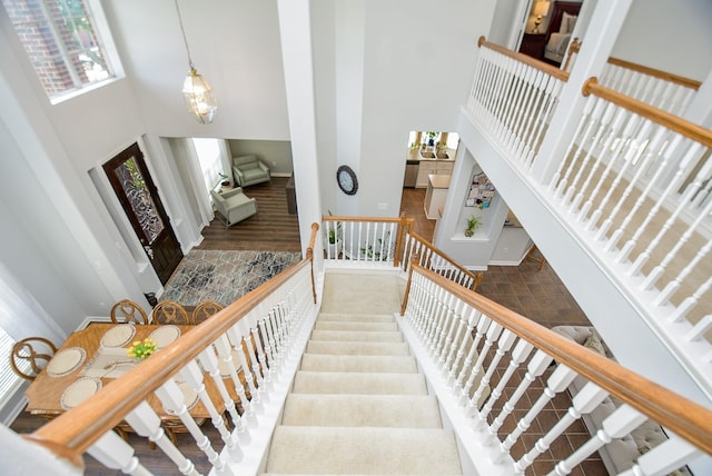 staircase featuring a high ceiling and baseboards